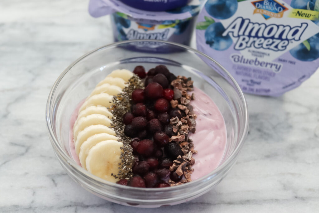 Healthy Toddler Snack Idea: Almond Breeze Blueberry Yogurt Smoothie Bowl With Superfood Toppings. Bananas, chia seeds, blueberries and cacao nibs.